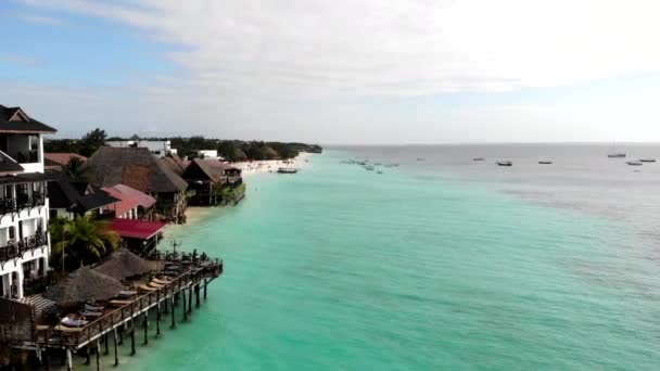 Prachtig uitzicht vanuit de lucht op het prachtige turquoise water en de witte zandkust in Zanzibar, Tanzania. Toeristische badplaats met traditionele comfortabele huisjes en hotels, ontspanningszone en perfecte keuken — Stockvideo