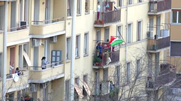 ROME, ITALY - MARCH 15, 2019: National italian flash mob in Rome, 시민들은 발코니에 기를 들고 노래를 부르며, 치명적 인 코로나 바이러스가 유행하던 시기에 단결 했다. 격리 된 사람들 — 비디오