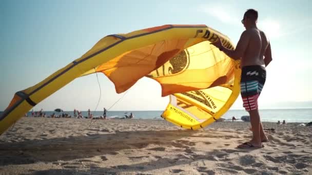 REGGIO DI CALABRIA, WŁOCHY - sierpień 2019: Turniej kitesurfingu w Reggio di Calabria, surfer w okularach przeciwsłonecznych podnoszący żółty latawiec, sporty ekstremalne wodne we Włoszech — Wideo stockowe