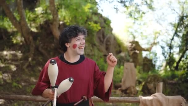 CANALE MONTERANO, ITALY - MAY 2018: Two funny jugglers on medieval festival in Monterano. Magicians dressed in traditional clothes using juggling clubs and balls for tricks performance. Reenactment of — Stock Video