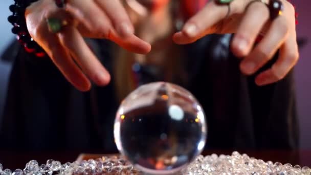 Close-up of mysterious crystal ball and witchs hands wondering above it. Black gypsy spelling for mischief or death, talking with spirits and afterlife, demons and evil. Fight between good and evil — Stock Video