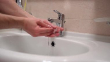 Salgın hastalık dönemi, virüs yayılması enfeksiyon, bakteri ve mikrop bulaşmasın diye ellerini dikkatlice yıkayan adam. Kirli elleri temizlemek için dezenfektan sabun, insan refahı