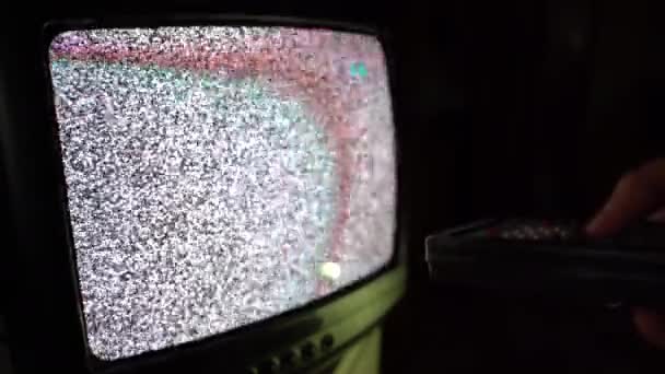 Régi vintage televízió zajinterferenciával a képernyőn. Férfi kézben tartja a TV távirányítót és csatornát vált. Régi televízió és adás, csatornák szörfözés és törött kábel jel. Régi TV — Stock videók