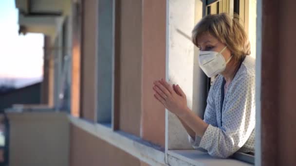 Вспышка коронавируса в Лондоне, борьба с вирусной инфекцией и поддержка тех, кто жертвует жизнью, чтобы помочь инфицированным пациентам. Женщина в медицинской маске аплодирует медицинским работникам, поддерживает национальную — стоковое видео
