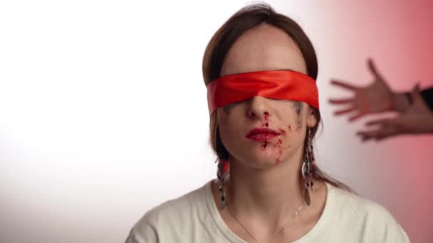 Zbitá žena se zavřenýma očima a krvácejícím nosem sedící na pozadí gestikulujícího muže. Agresivita proti ženám v rodině, tyranii a otroctví — Stock video