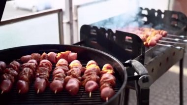 Lezzetli et çeşitleri, metal bbq ızgarasında ızgara, dışarıda yanan kömürlü iki Brezilya biberi. Sosis dilimleri ve salamura edilmiş sebzeli tavuk şişte kızartılmış ve dumanı tüten kömür gibi.