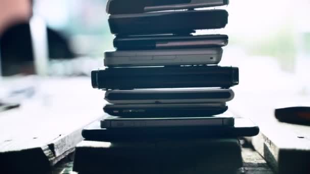 Une pile de vieux téléphones portables vintage de différents modèles et marques, des modèles de téléphone à l'ancienne, des téléphones usagés et obsolètes — Video