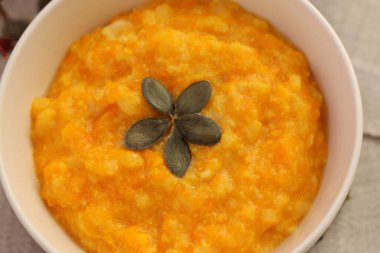 Taze balkabağı lapası, beyaz tabakta kabak çekirdeği.