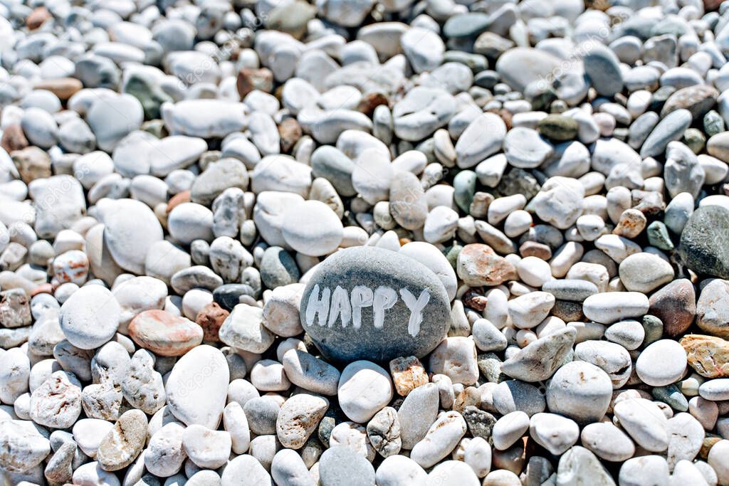 stones on the beach with a blue sea and the inscription