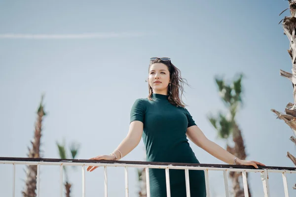 A beautiful young brunette girl is walking in the city in sunglasses and posing for the camera. Sunny weather and promenade in Antalya — Stock Photo, Image