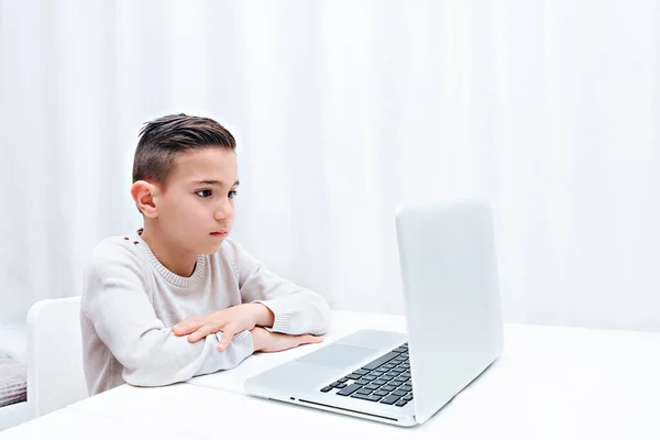 Дитина навчається онлайн, сидячи на комп'ютері. Дитина слухає вчителя — стокове фото