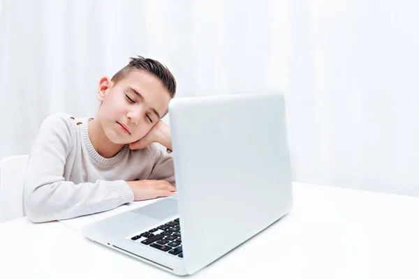 Дитина навчається онлайн, сидячи на комп'ютері. Дитина слухає вчителя і слідує за сном — стокове фото