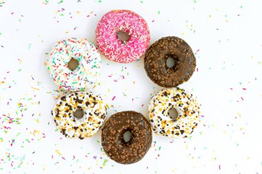 Donutlar süslemeli ve beyaz arkaplana serpiştirilmiş 