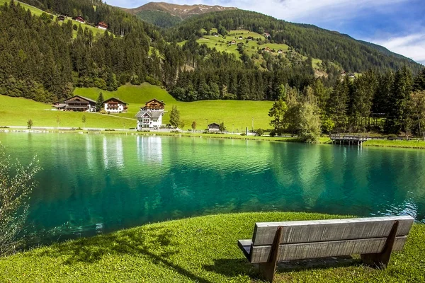 Wooden bench in front of the Muehlwald reservoir in Muehlwald So — 스톡 사진