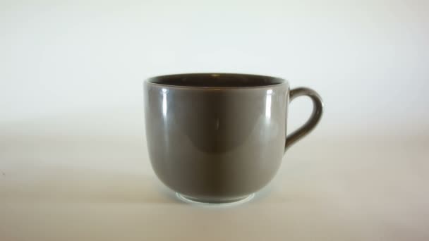 verser des grains de café dans une grande tasse de café 