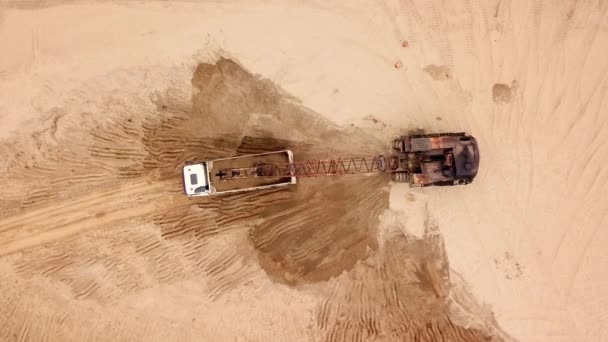 Прямо над видом на экскаватор льет песок — стоковое видео