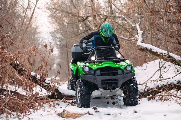 Jeździec jazdy w wyścigu quadbike zimą w lesie. — Zdjęcie stockowe