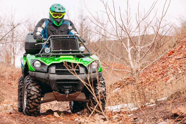 Jeździec jazdy w wyścigu quadbike zimą w lesie. — Zdjęcie stockowe