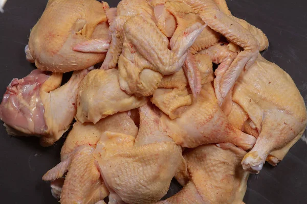 Frango de corte e sua carne em um fundo preto . — Fotografia de Stock