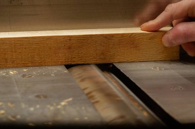 Genç marangoz ahşap üretim için ahşap parçalar yapıyor.