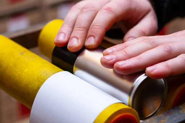 Aplicación manual de pegatinas en latas de aerosol con automoción a — Foto de Stock