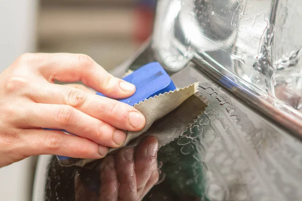 An employee of the car wash thoroughly washes conducts detaling — Stock Photo, Image