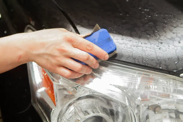 Um funcionário da lavagem de carro lava completamente realiza detalhamento — Fotografia de Stock