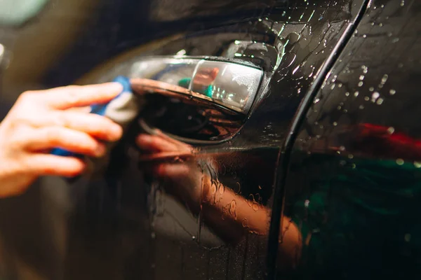 Um funcionário da lavagem de carro lava completamente realiza detalhamento — Fotografia de Stock