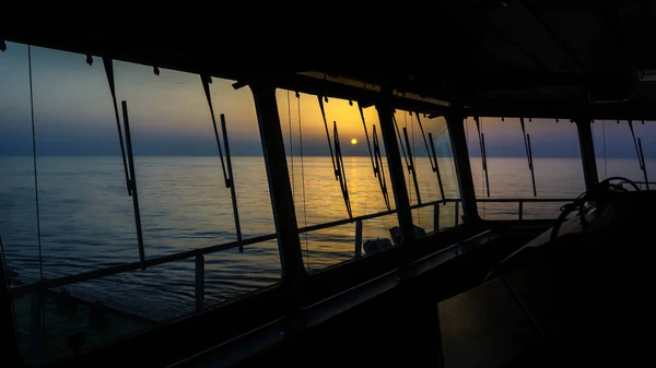 Sunset door schepen ramen — Stockfoto