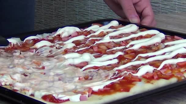 El chef pone los ingredientes encima de la pizza cruda, preparándola para hornear. . — Vídeos de Stock