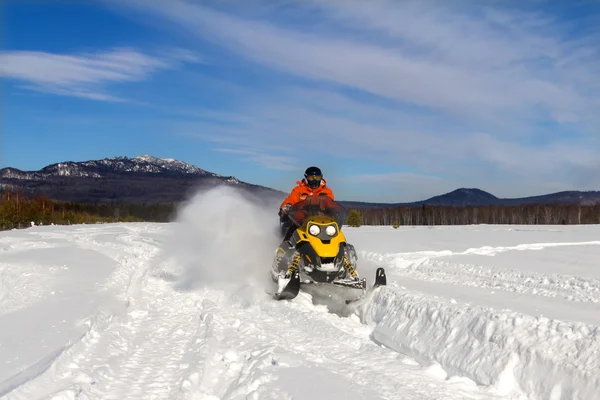 Atleta em uma moto de neve. — Fotografia de Stock