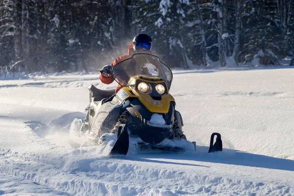 Atleta em uma moto de neve — Fotografia de Stock