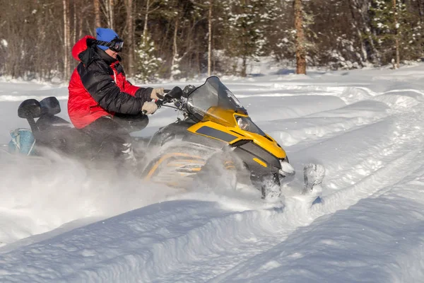 Atleta em uma moto de neve — Fotografia de Stock