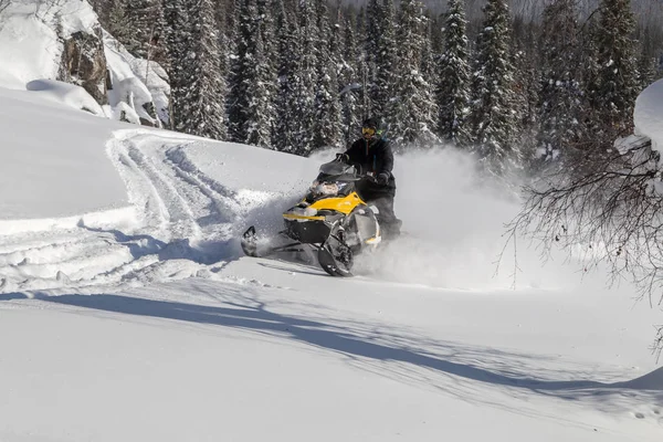 Atleta em uma moto de neve — Fotografia de Stock