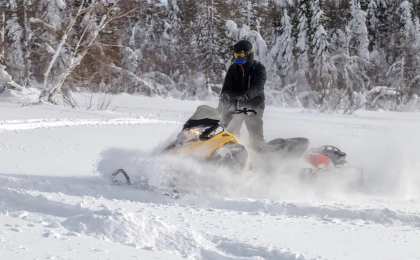 Atleta em uma moto de neve — Fotografia de Stock