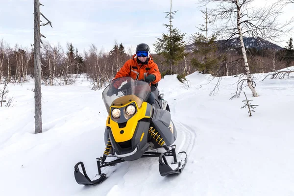 Atleta em uma moto de neve — Fotografia de Stock