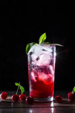 Koyu bir arka plan üzerinde şeffaf bir cam buz ile Kiraz limonata.