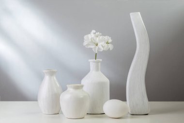 Beyaz yemekler ve hafif bir arka plan üzerinde bir vazoda çiçek.