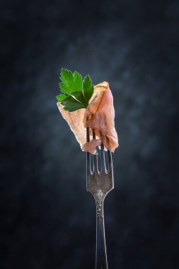 Pastırma ve maydanoz, arka planda bir çatal üzerinde.