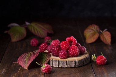 Ahşap arka plan üzerinde yaprakları ile taze ahududu