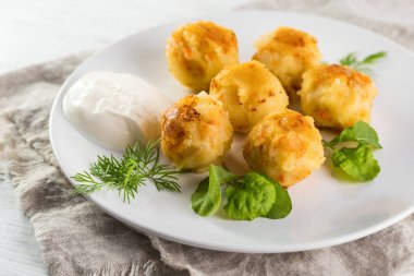 Patates kroketleri. Patates püresi ve yağda kızartılmış toplar. Kremalı sos ve otlarla servis edilir..
