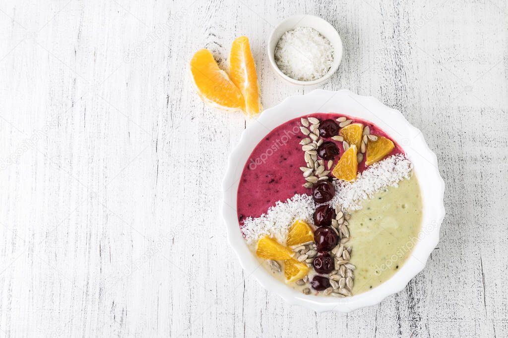Apple-currant smoothie Bowl with cherries, oranges, coconut flakes and sunflower seeds. Healthy breakfast.