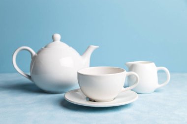 Mavi arkaplanda beyaz seramik tabaklar.