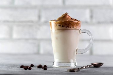 Buzlu Dalgona Kahve, yumuşak kremalı kremalı kahve açık renkli arka plan.