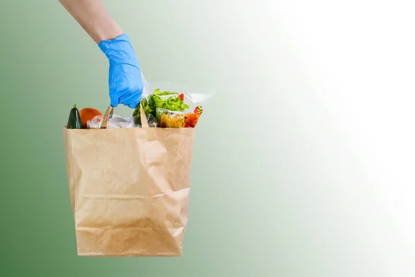 食料品店の配達サービスワーカーは コピースペース付きの手袋付き紙袋を提供します ストックフォト