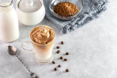 Buzlu Dalgona Kahve, yumuşak kremalı kremalı kahve açık renkli arka plan.