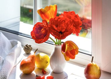 Pencere kenarında limonlu lale ve armut buketi.