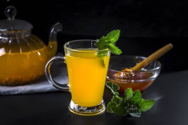 Koyu arkaplanda çaydanlıkta sıcak deniz dikenli çay..