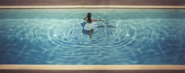 Молодая женщина в платье в бассейне — стоковое фото