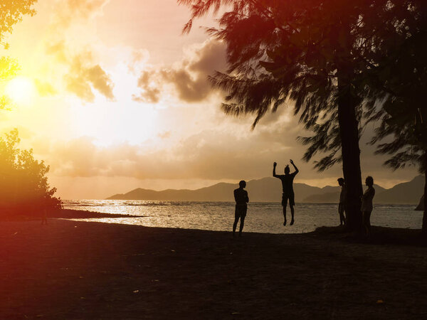 Teenagers walking on a tightrope at sunset 